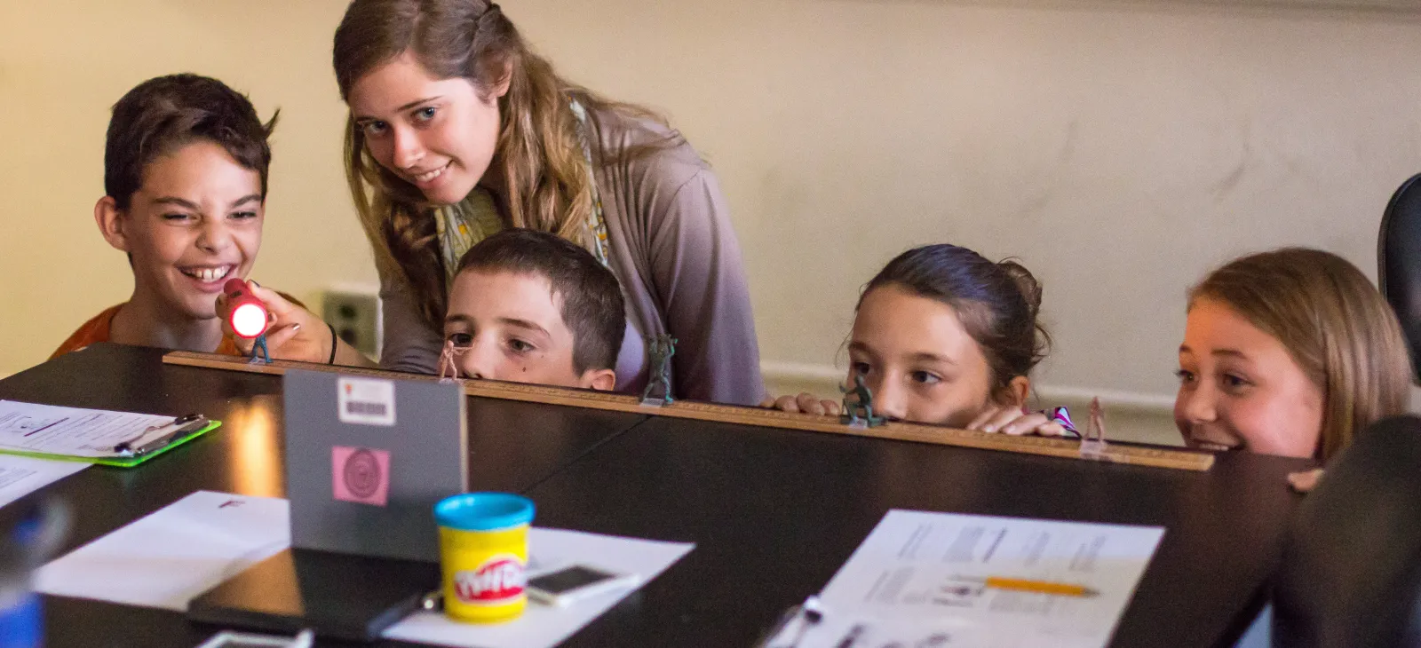 image of teacher with students at desk